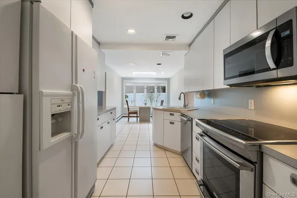 a kitchen with stainless steel appliances a refrigerator stove and microwave