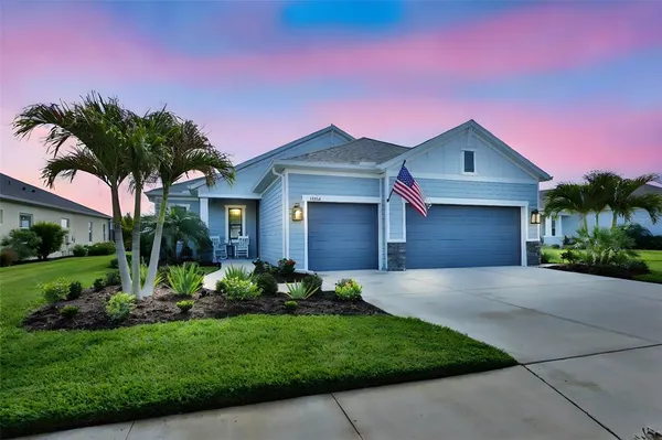 a front view of a house with a garden and tree