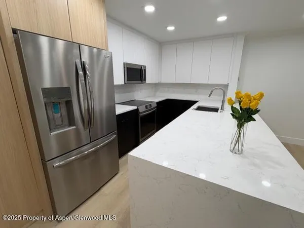 a kitchen with stainless steel appliances a refrigerator sink and cabinets
