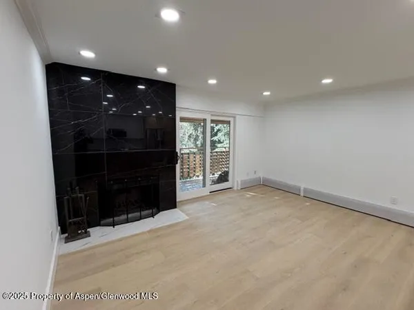 a view of an empty room with furniture and natural light