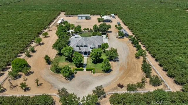 an aerial view of a house with a yard and trees all around