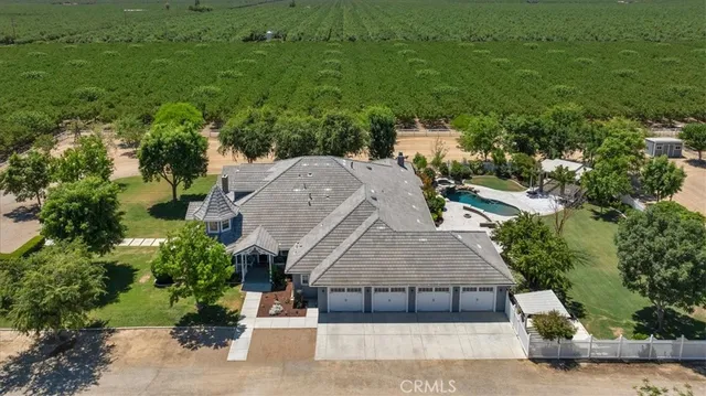 an aerial view of a house with a yard swimming pool a patio and lake view