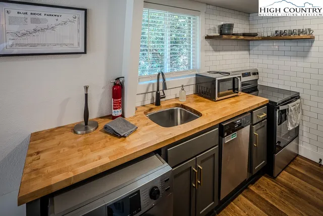 a kitchen with sink a refrigerator and wooden floor