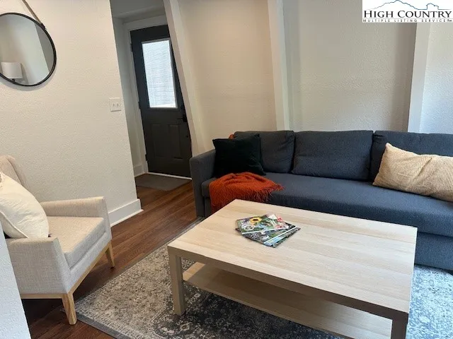 a living room with furniture a fireplace and a floor to ceiling window