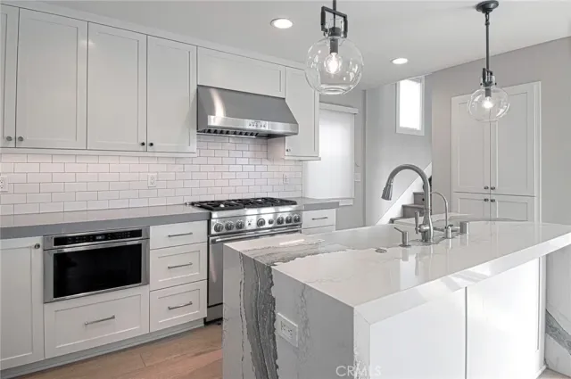 a kitchen with stainless steel appliances a sink a stove a microwave and cabinets