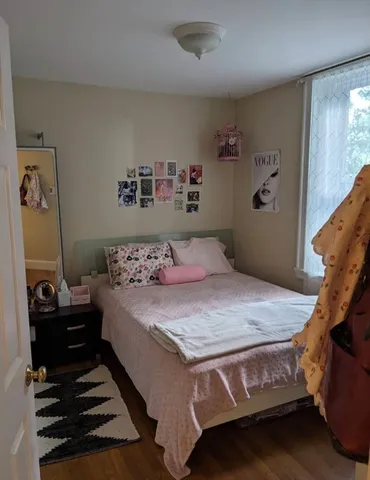 a bedroom with a bed and wooden floor