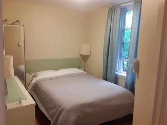 a bedroom with a bed and a window