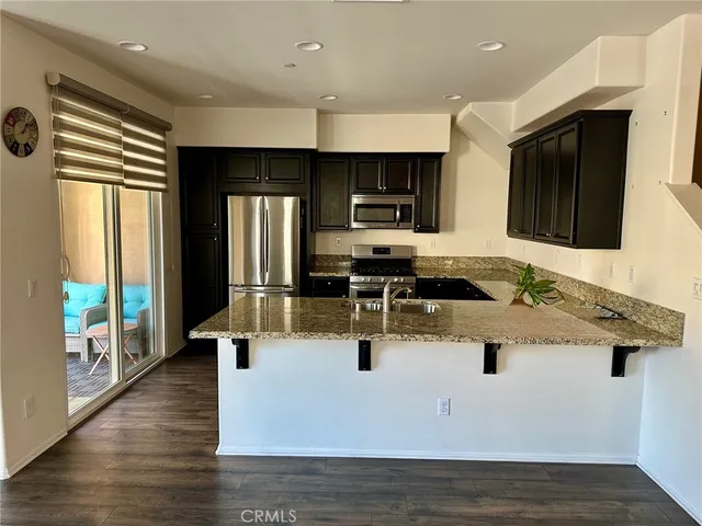 a view of kitchen with kitchen island stainless steel appliances a sink and counter space