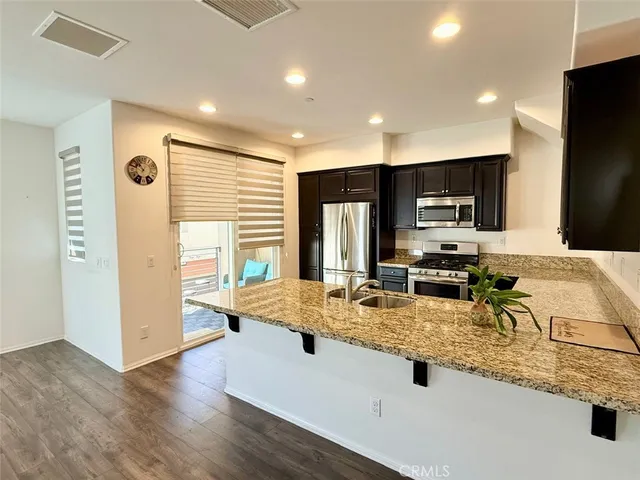 a kitchen with granite countertop a sink a counter top space appliances and cabinets