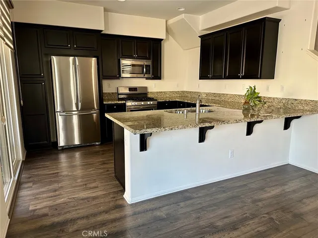 a kitchen with stainless steel appliances granite countertop a refrigerator and a sink