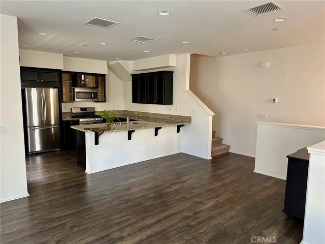 a kitchen with stainless steel appliances granite countertop a refrigerator and a stove top oven