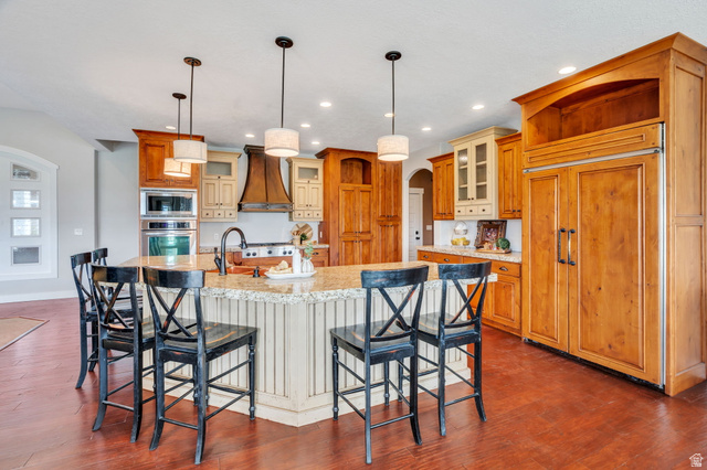 1355 West 1000 South Mapleton, UT 84664 - Photo 12 of 74 Kitchen featuring arched walkways, built in appliances, a kitchen bar, a spacious island, and dark wood-style floors