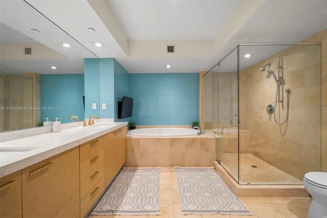 a bathroom with a large tub shower and sink
