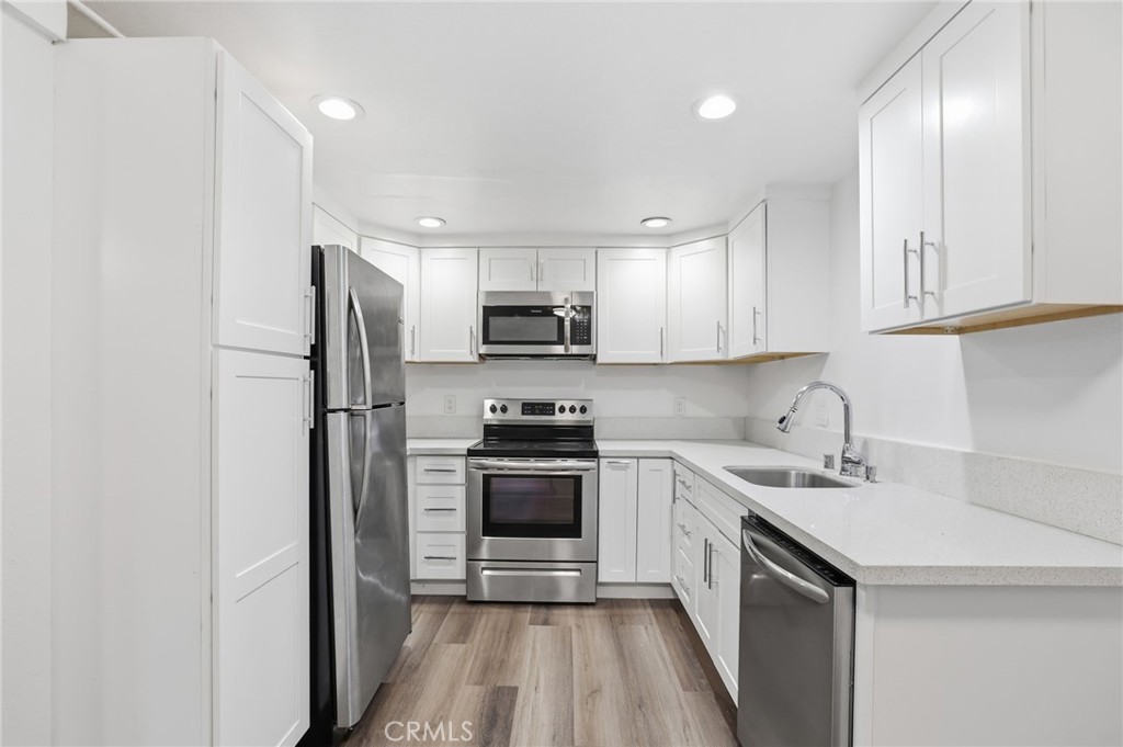 3370 Pachappa Hill Riverside, CA 92506 - Photo 25 of 36 a kitchen with a sink a refrigerator a microwave and cabinets