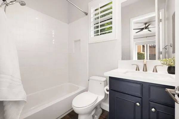 a bathroom with a sink toilet vanity tub and shower