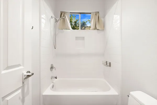 a white bath tub sitting next to a white toilet