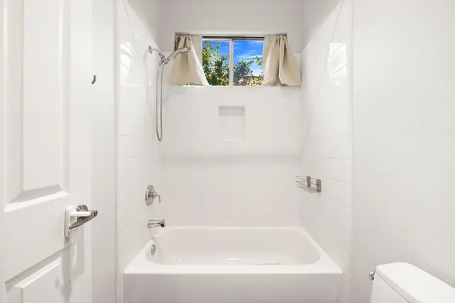 a white bath tub sitting next to a white toilet