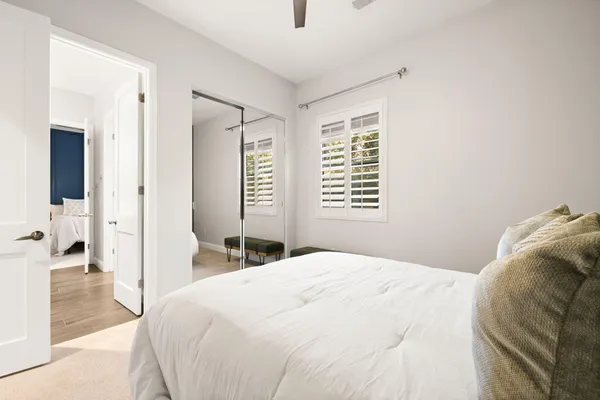 a bedroom with a bed and a large mirror