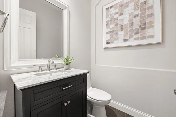 a bathroom with a granite countertop sink toilet and a mirror