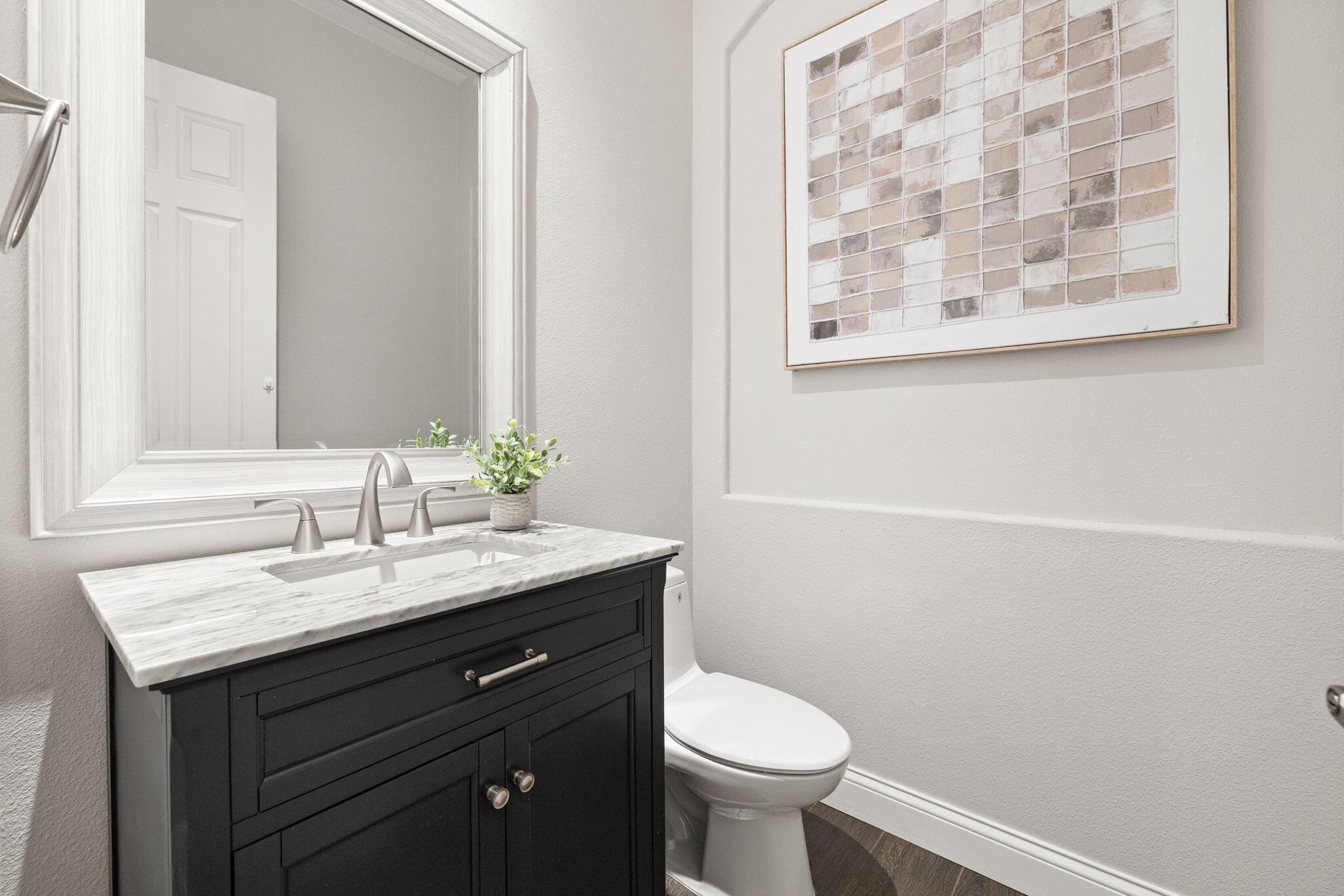 48864 Pear Street Indio, CA 92201 - Photo 36 of 46 a bathroom with a granite countertop sink toilet and a mirror