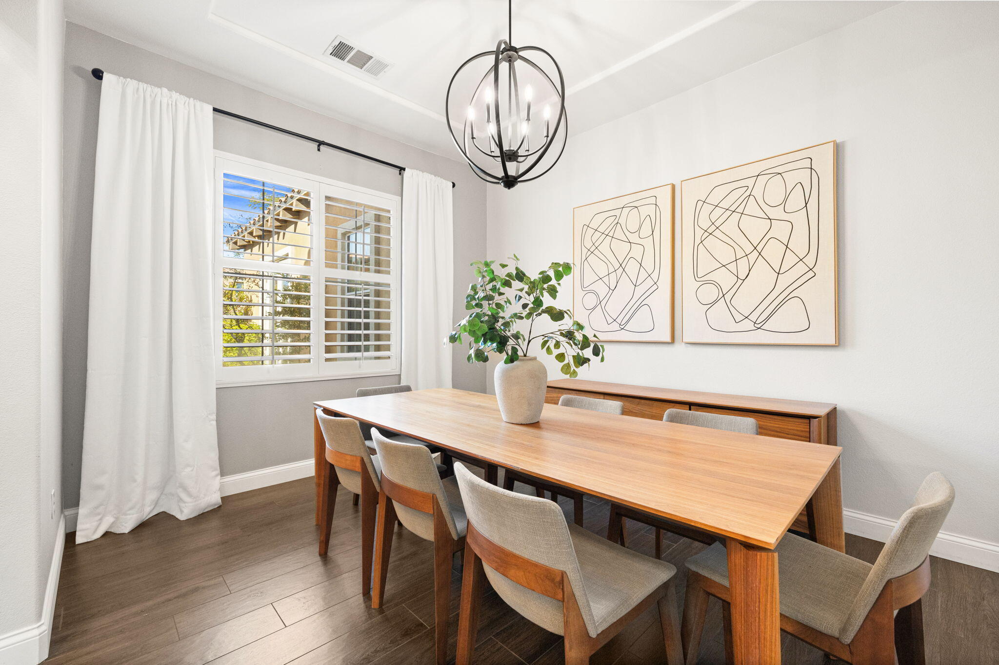 48864 Pear Street Indio, CA 92201 - Photo 5 of 46 a dining room with wooden floor a chandelier a wooden table and chairs