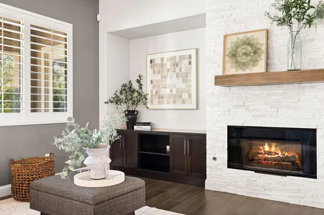 a living room with furniture a fireplace and a large window