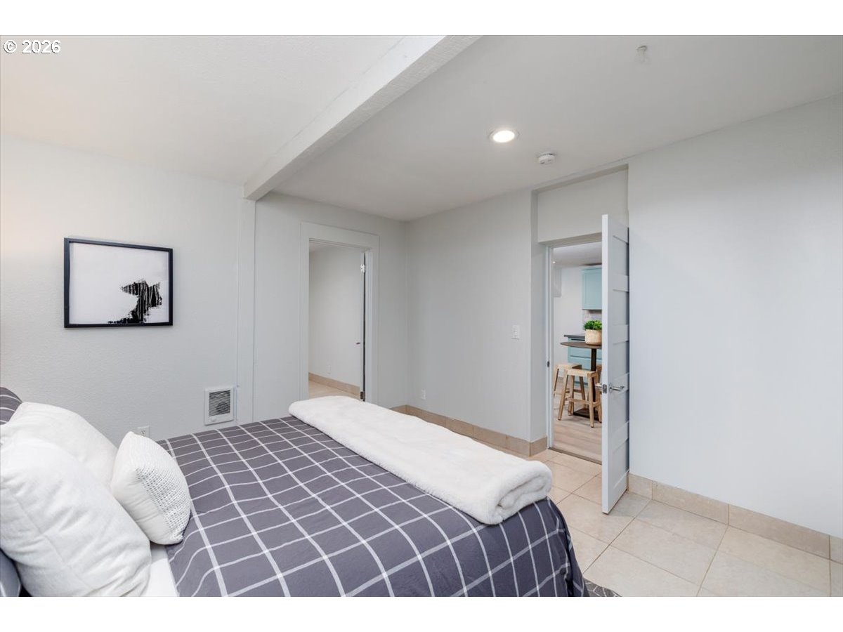 3827 Southwest Dolph Court Portland, OR 97219 - Photo 38 of 48 a bedroom with a large bed and a chandelier