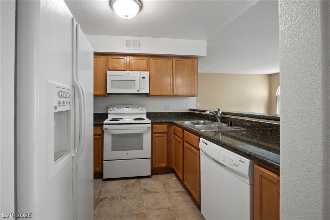 3145 East Flamingo Road, Unit 1055 Las Vegas, NV 89121 - Photo 15 of 40 Functional kitchen offers ample cabinetry, a full suite of appliances, and convenient pass-through counter to adjacent living space.
