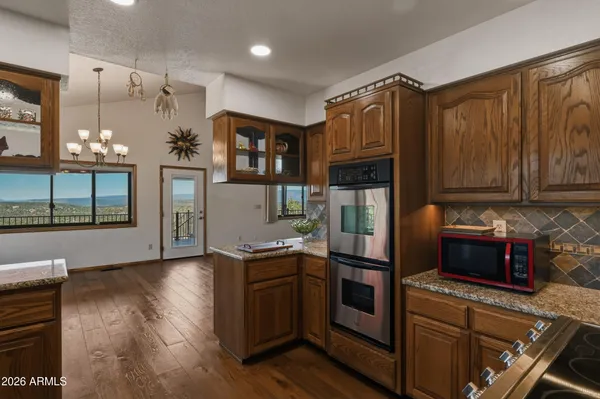 an empty room with wooden floor closet and windows