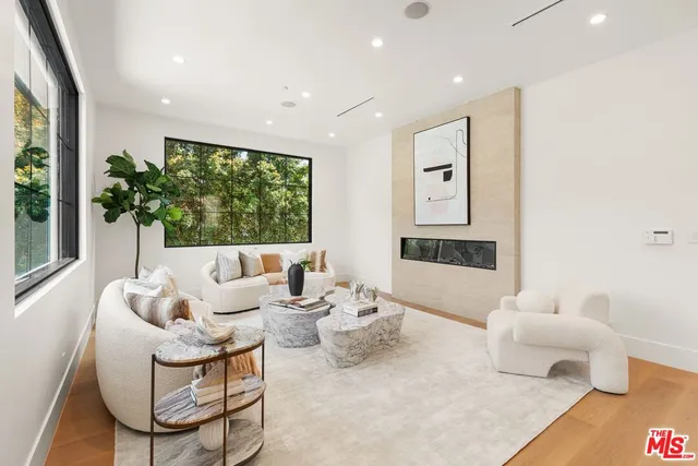 a living room with furniture a table and kitchen view