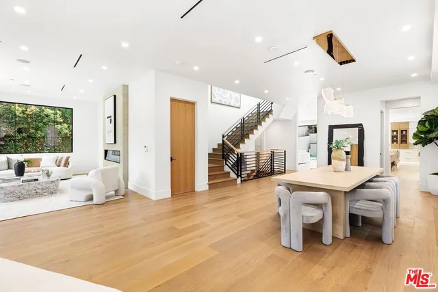 a kitchen with a table chairs and white cabinets