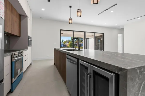 a kitchen with stainless steel appliances granite countertop a refrigerator a oven and a sink