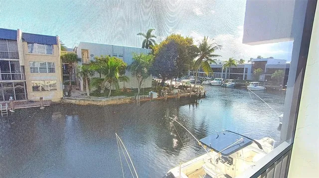 a view of a chairs and table in a patio with a lake view