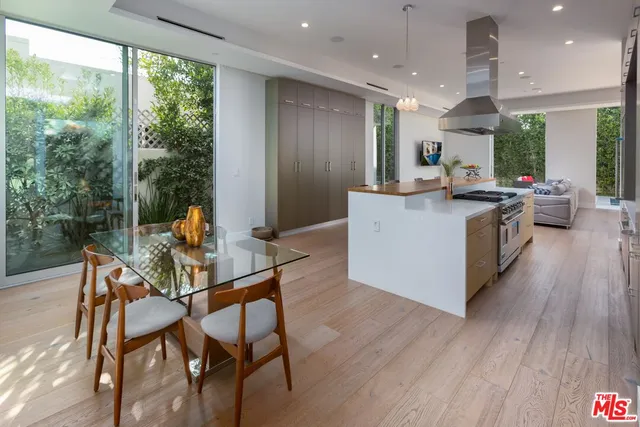 a kitchen with a table chairs and wooden floor