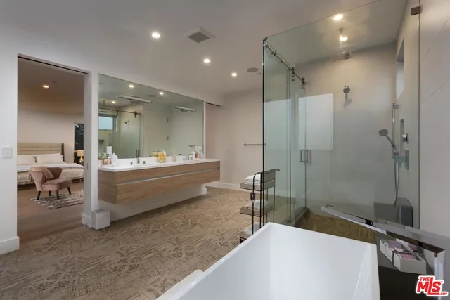 a bathroom with a double vanity sink a toilet a mirror and shower