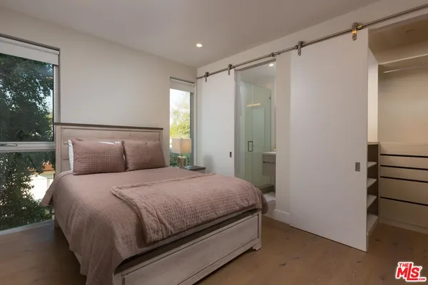 a bedroom with a bed and a painting on the wall