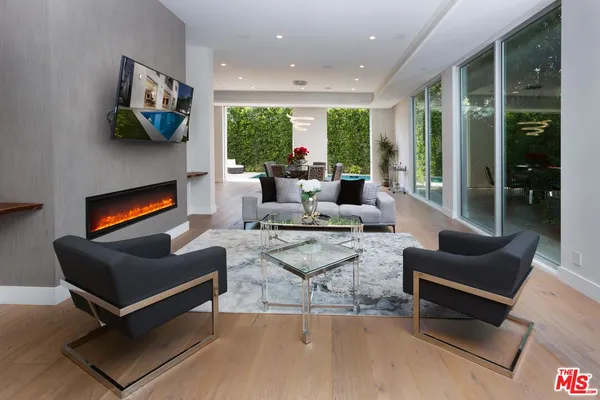 a living room with furniture fireplace and a large window