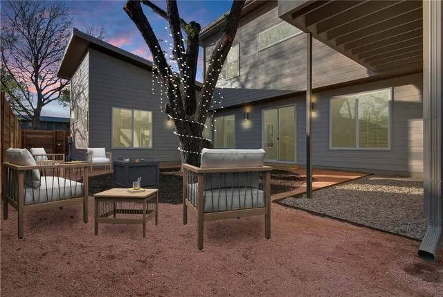 a view of a house with backyard and sitting area