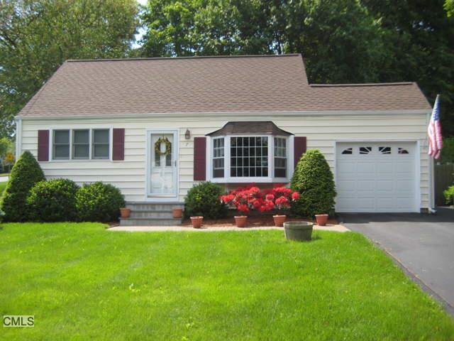 a front view of a house with a garden and yard