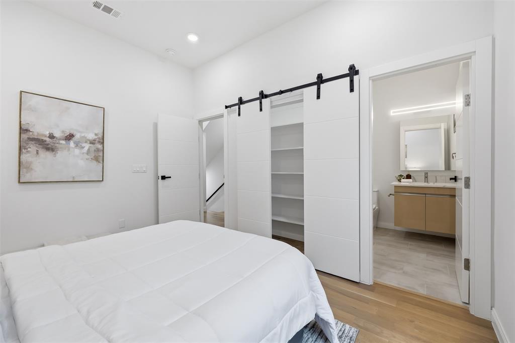 1920 Caddo Street, Unit 204 Dallas, TX 75204 - Photo 23 of 33 a bedroom with a bed and a view of bathroom