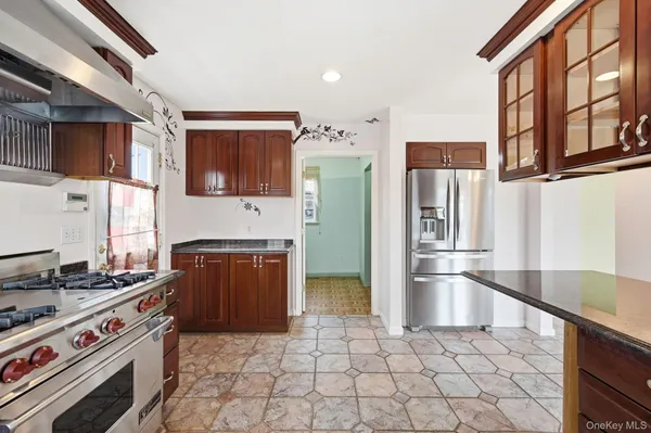 a kitchen with stainless steel appliances granite countertop a refrigerator and a stove
