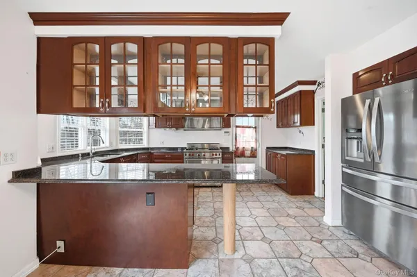 a kitchen with stainless steel appliances granite countertop a stove a sink and a refrigerator