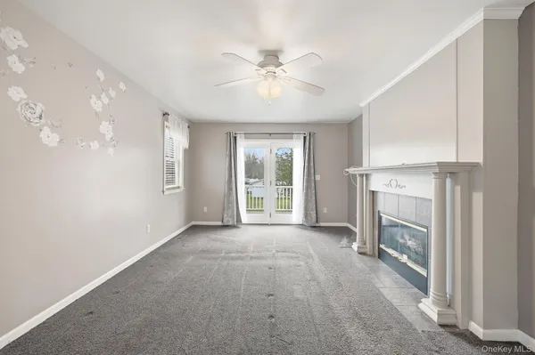 a view of an empty room with a fireplace and a window