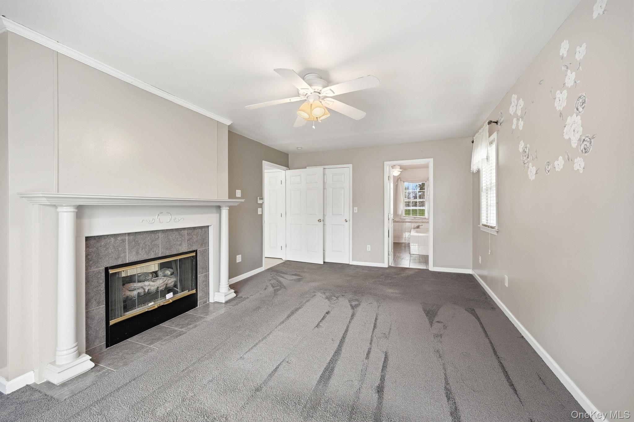 186 Violet Avenue Poughkeepsie, NY 12601 - Photo 30 of 50 a view of a livingroom with a fireplace a ceiling fan and wooden floor