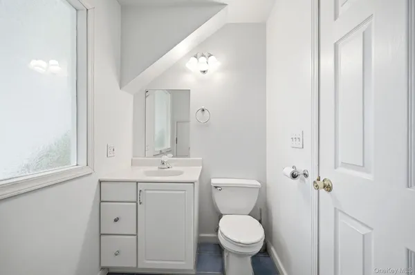 a bathroom with a toilet sink a mirror and vanity