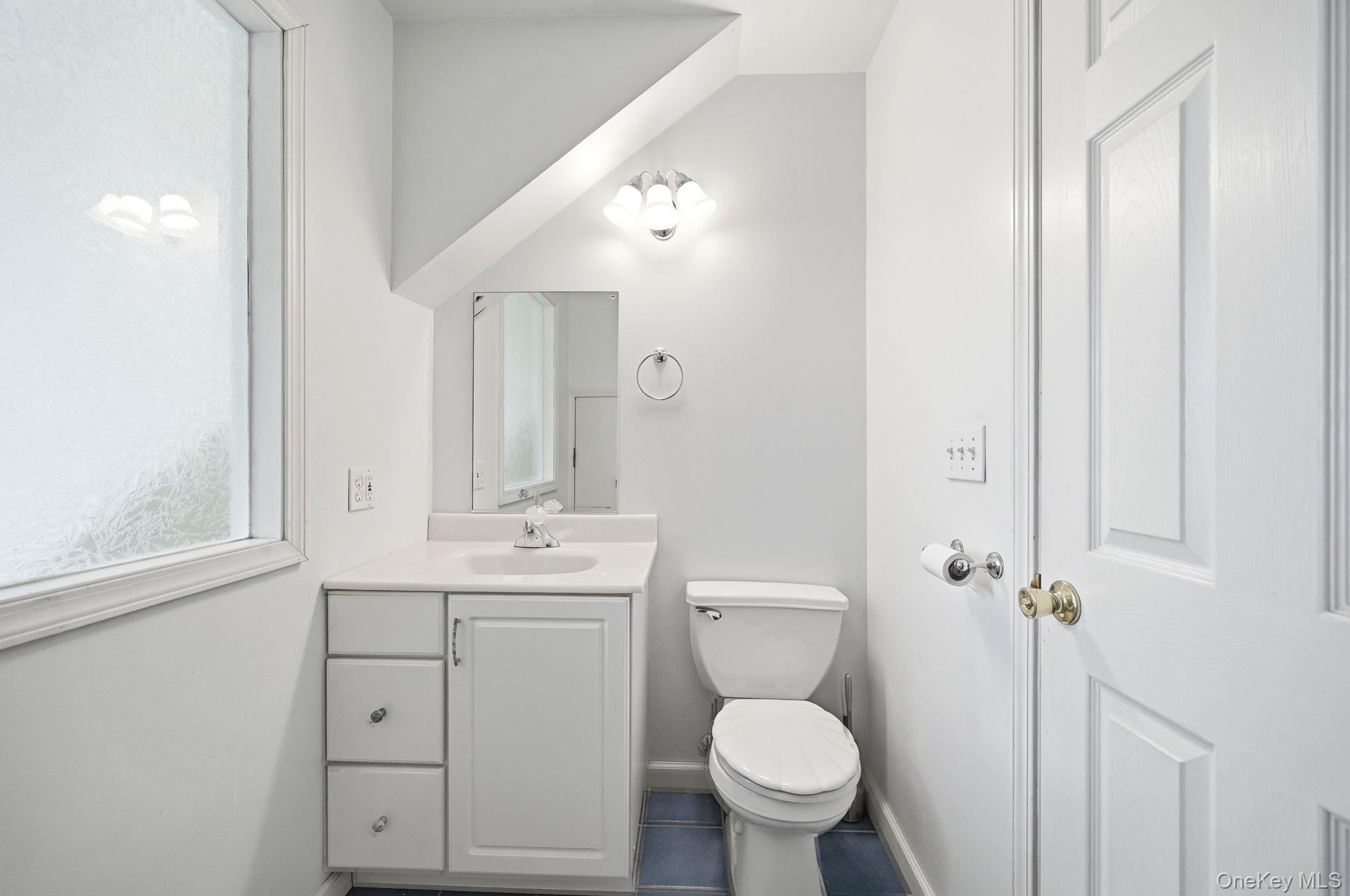 186 Violet Avenue Poughkeepsie, NY 12601 - Photo 40 of 50 a bathroom with a toilet sink a mirror and vanity