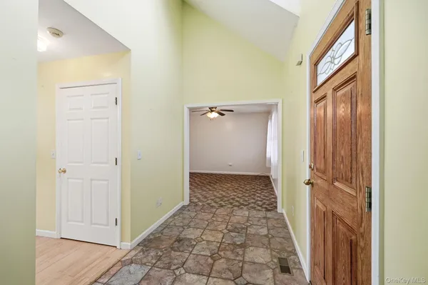 a view of a hallway with wooden floor and a bathroom