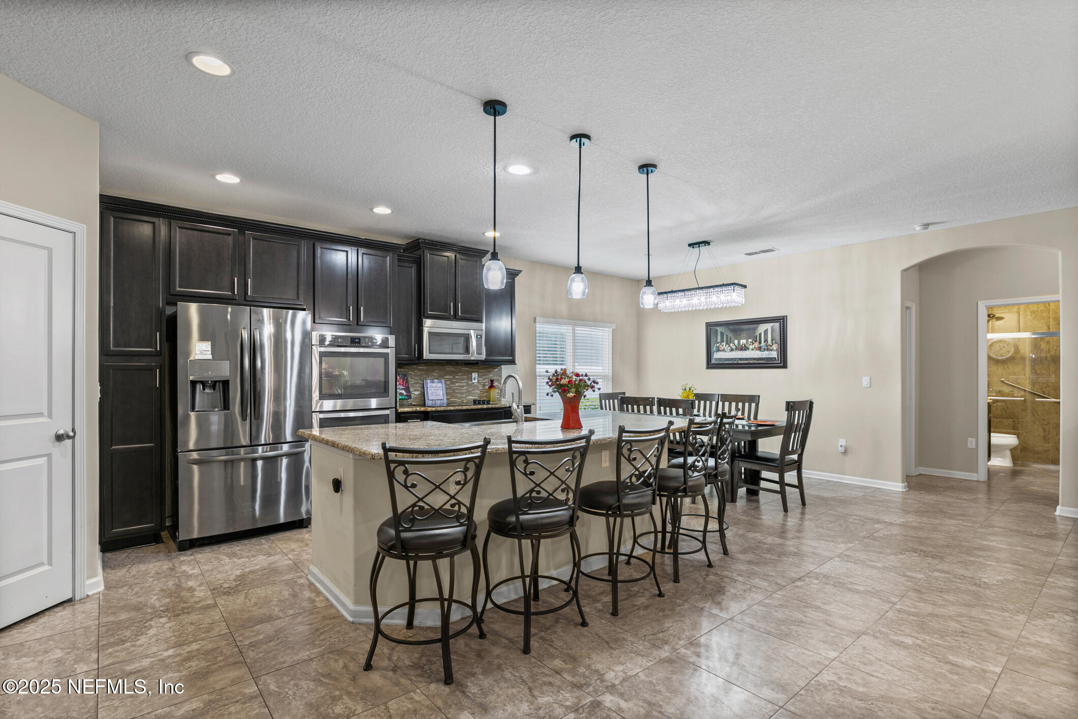 200 Ellsworth Circle St. Johns, FL 32259 - Photo 11 of 48 a kitchen with stainless steel appliances kitchen island granite countertop a dining table chairs and refrigerator