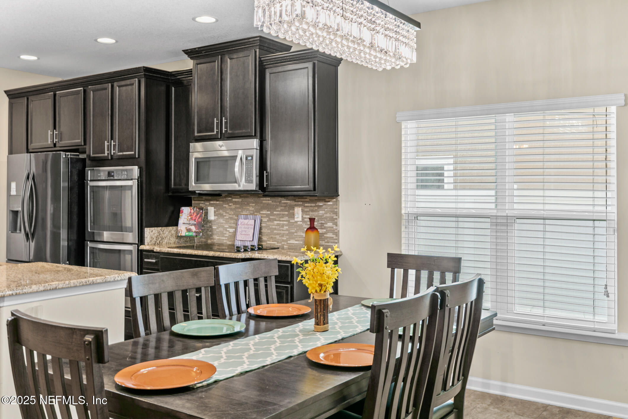 200 Ellsworth Circle St. Johns, FL 32259 - Photo 18 of 48 a kitchen with stainless steel appliances granite countertop a refrigerator a stove a sink dishwasher with a dining table and chairs