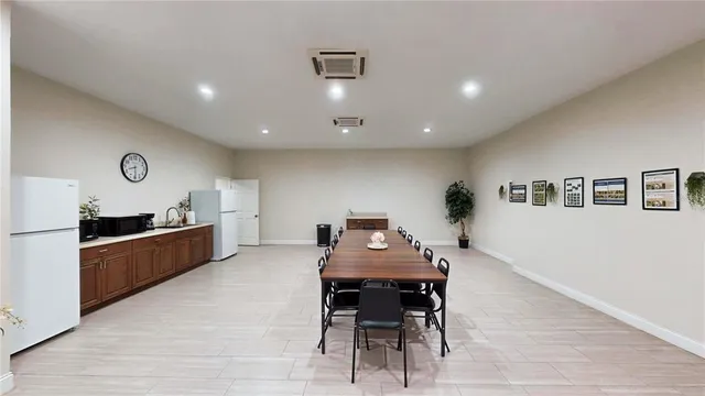 a kitchen with stainless steel appliances kitchen island a dining table and chairs